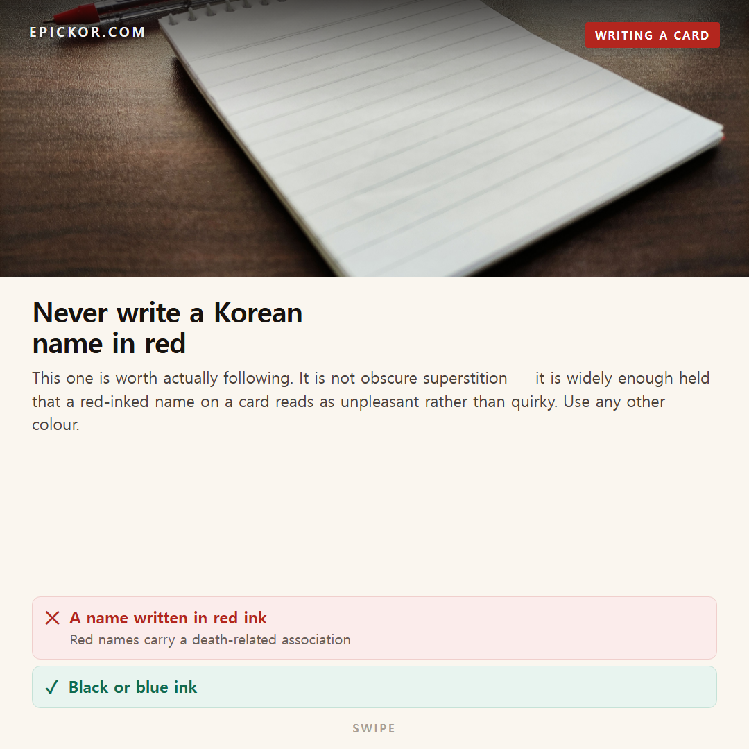A red pen lying beside a lined notepad