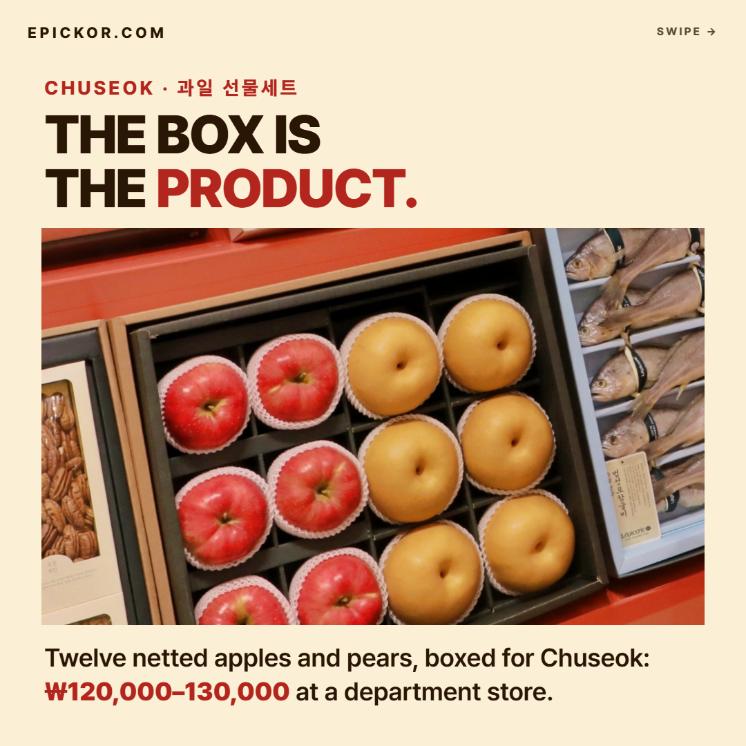Chuseok 2026 gift display at Lotte Department Store — a box of six red apples and six Korean pears, each in a foam net, beside dried-fish and nut gift sets (price not shown)