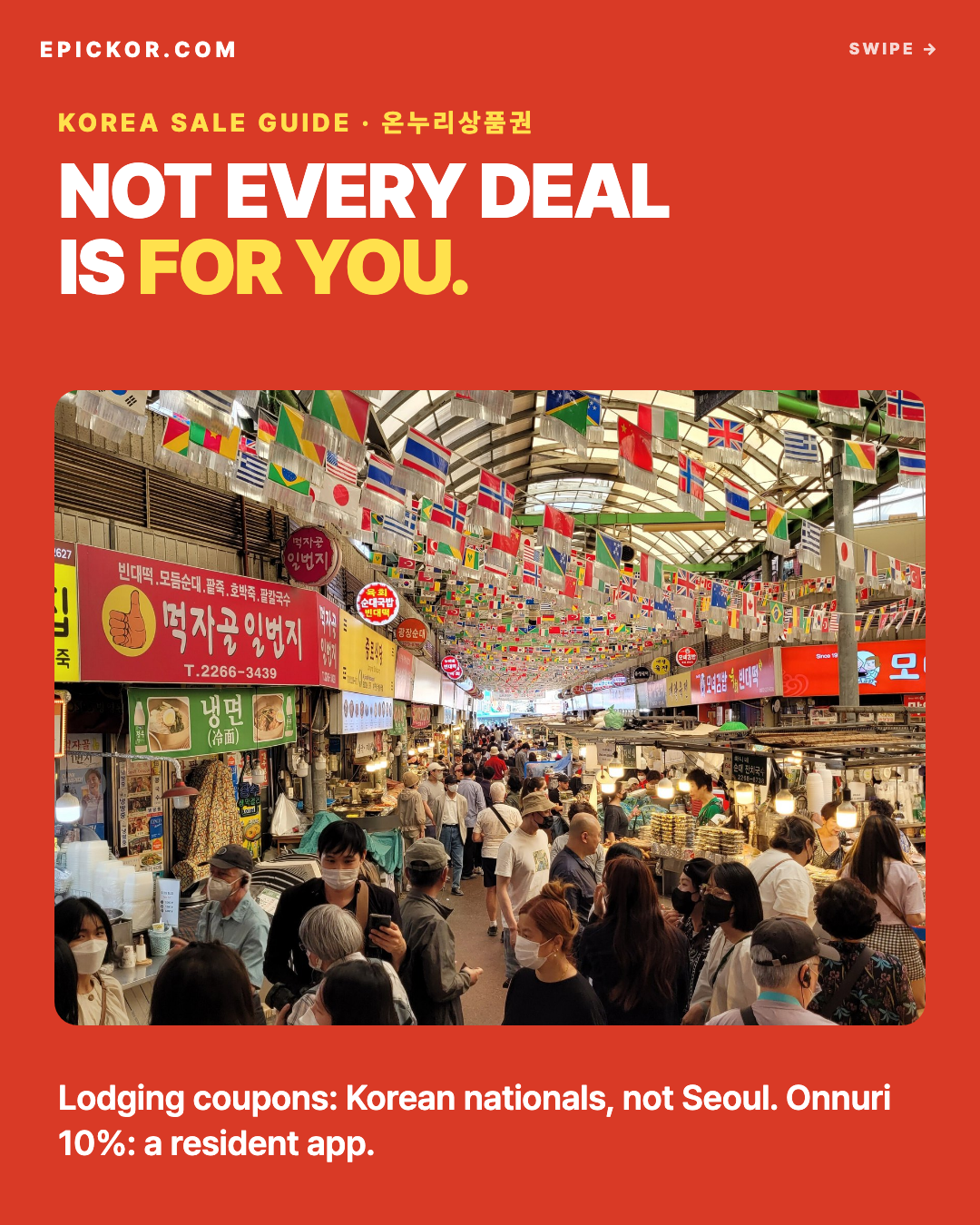 Gwangjang Market, Seoul, September 2022 — a crowded covered aisle of food stalls under strings of national flags, Korean shop signs on both sides