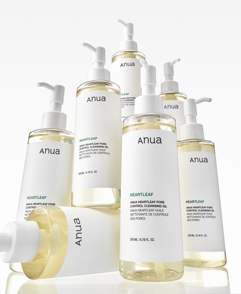 Several Anua Heartleaf Pore Control Cleansing Oil pump bottles grouped together, with pale yellow oil visible through the clear plastic.