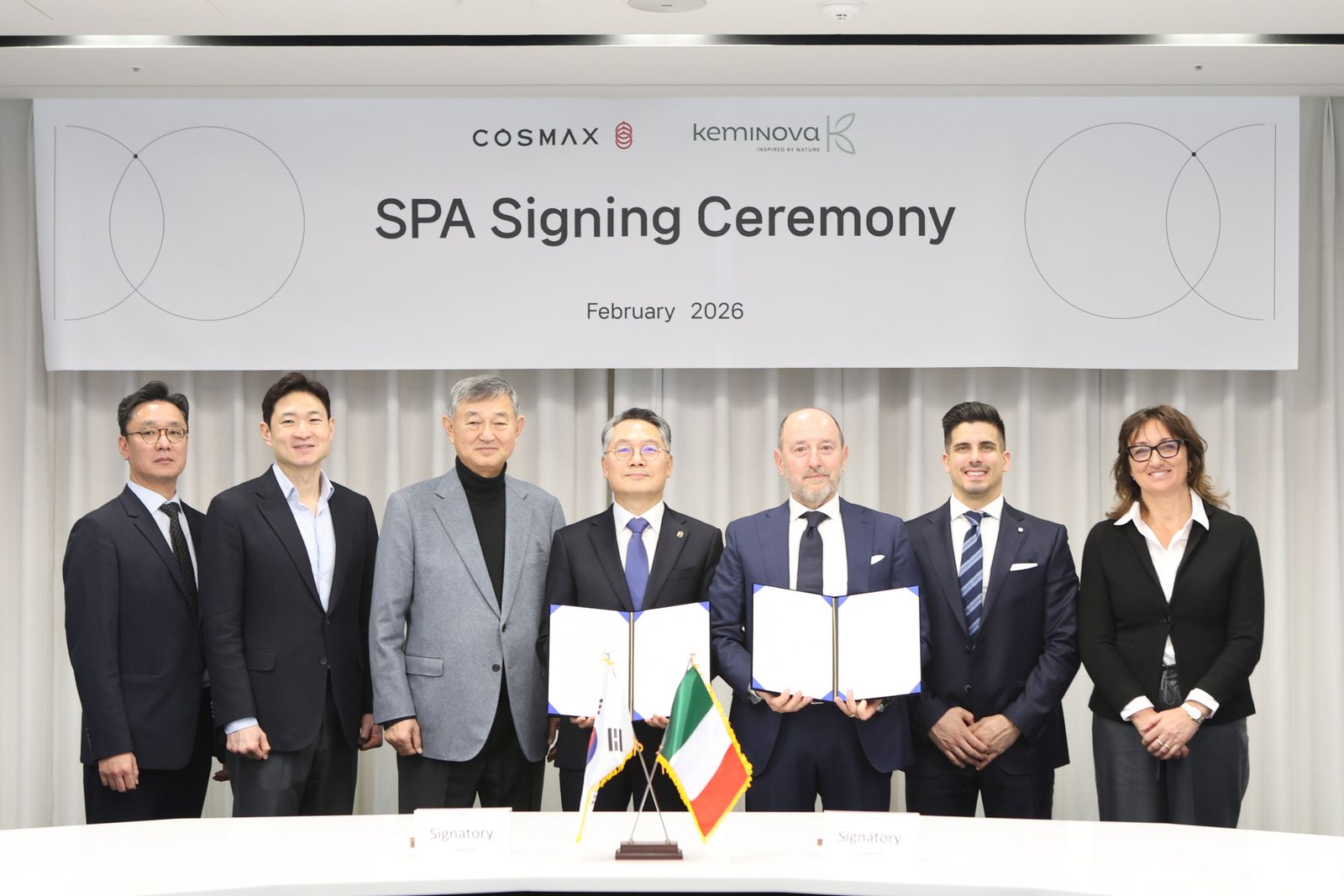 COSMAX and Keminova representatives hold signed documents at the February 2026 acquisition ceremony.