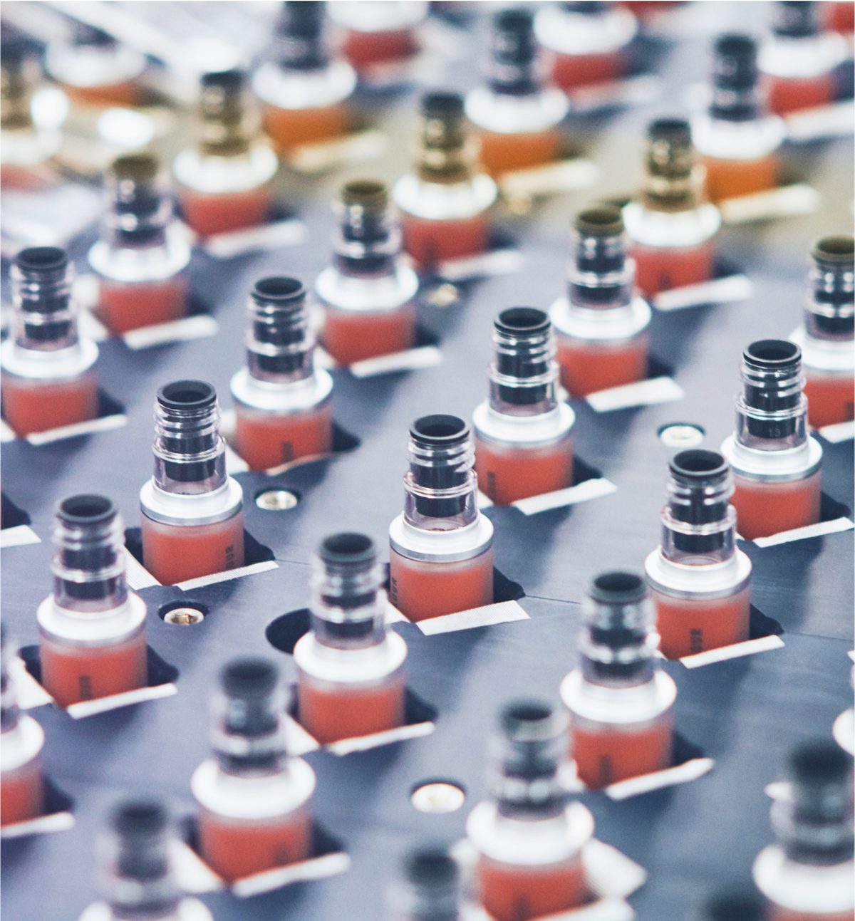 Rows of cosmetic containers move through an official COSMAX production process.