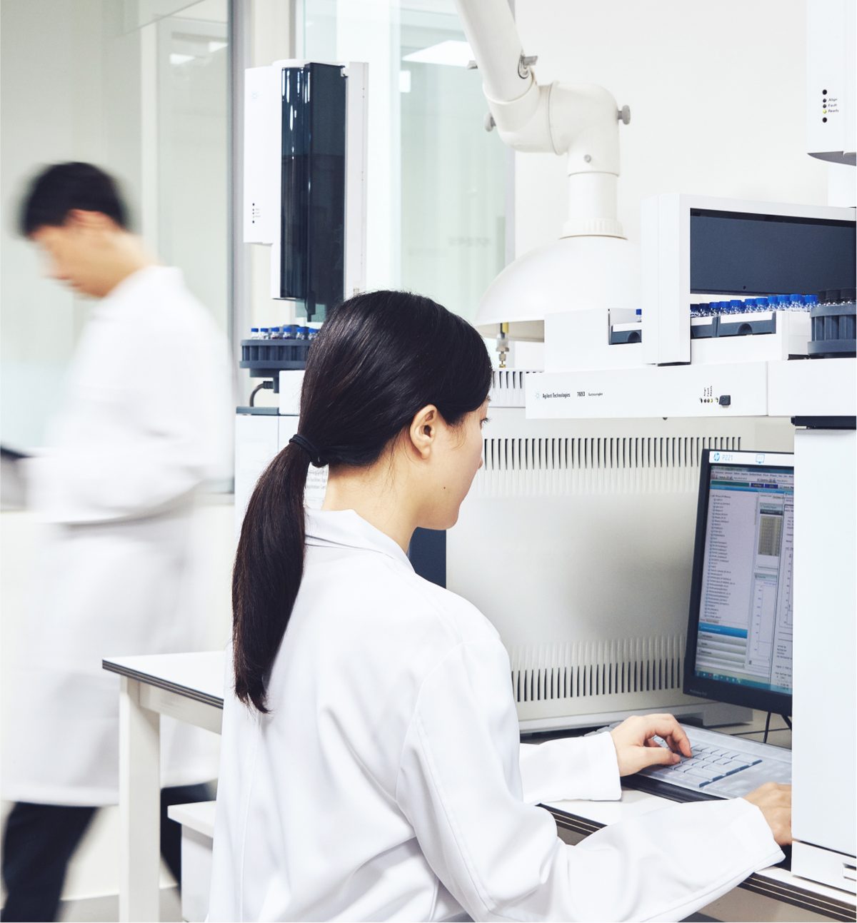 A COSMAX researcher works with laboratory analysis equipment at an official company research facility.