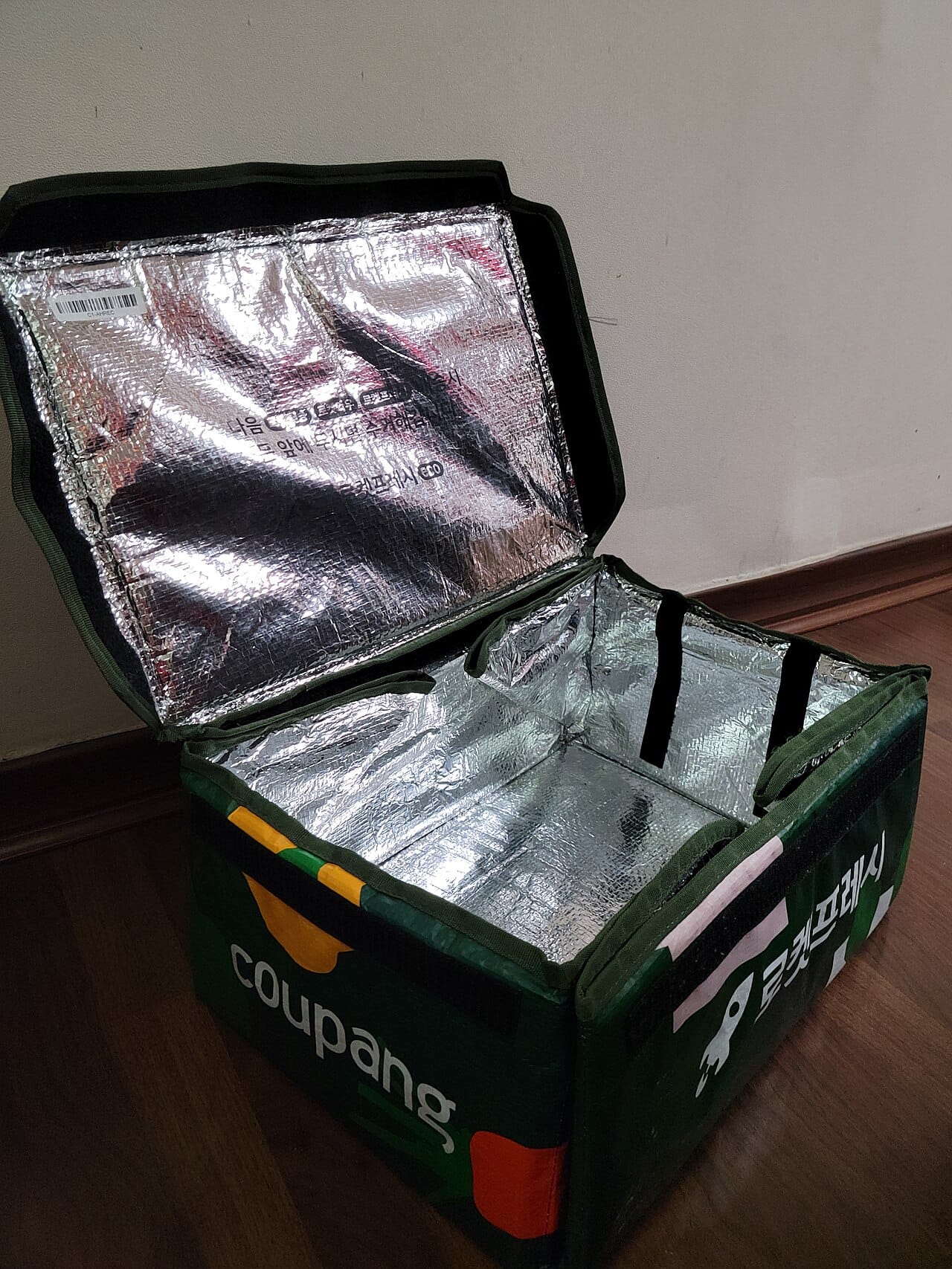 A real Coupang-branded insulated grocery delivery bag, shown open, marked with Coupang and Rocket Fresh branding.