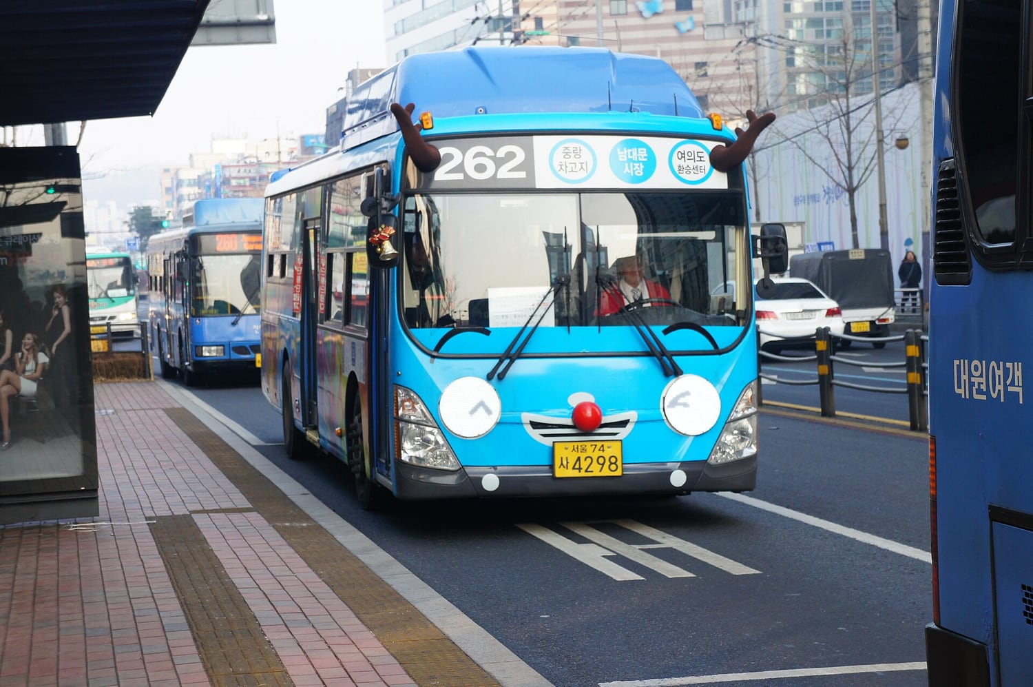 A blue Seoul city bus on route 262 in Tayo livery, additionally fitted with reindeer antlers and a red nose for the Christmas season.
