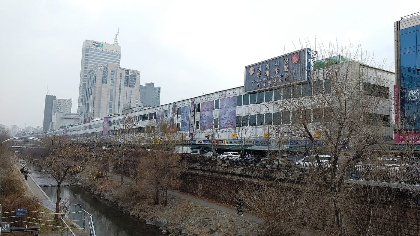 Pyounghwa Fashion Plaza, a Dongdaemun wholesale apparel market building, seen along Cheonggyecheon in Seoul.
