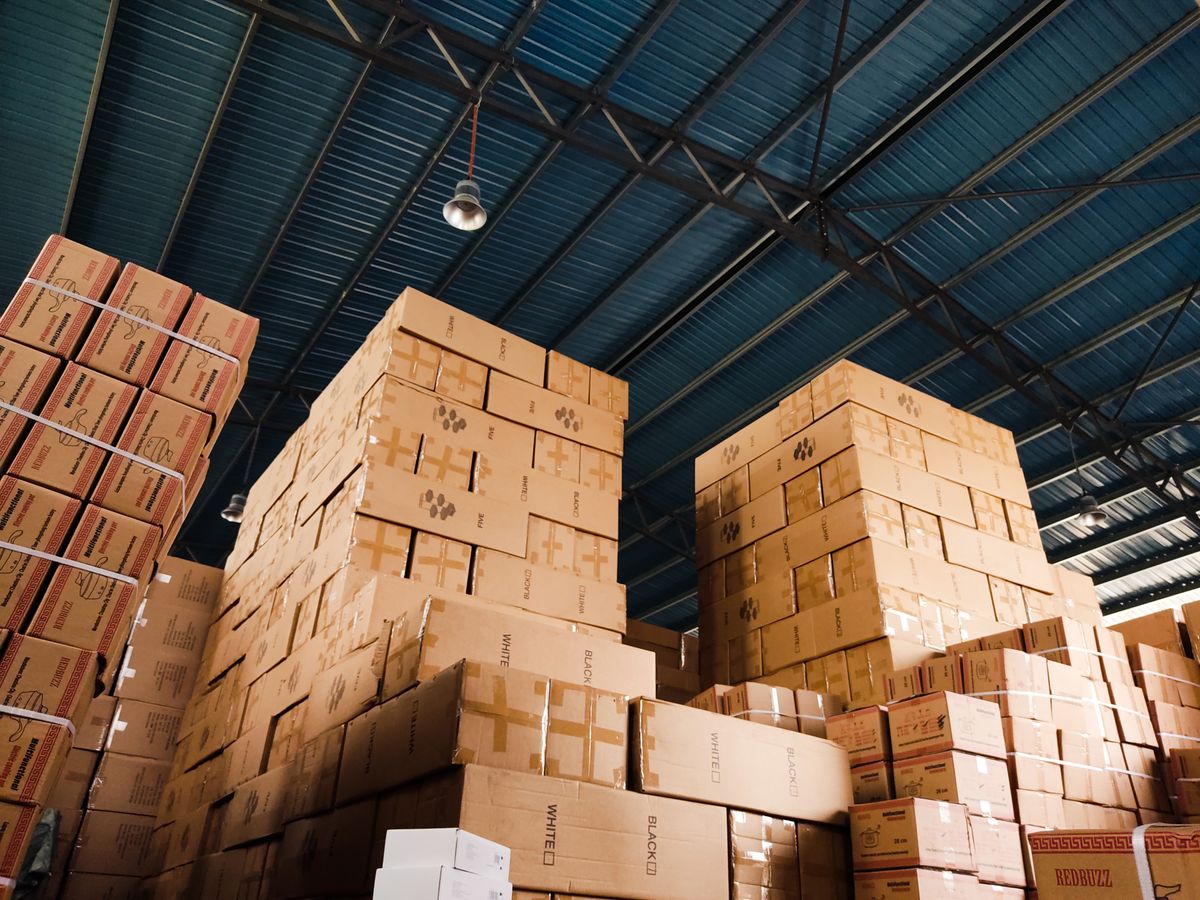 Stacked export cartons in a warehouse show why shipping packaging, carton strength, pallet patterns, and handling conditions need a separate supplier check.