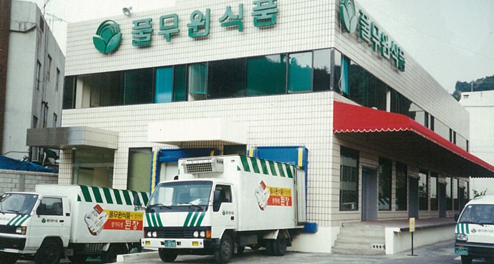 An early Pulmuone Foods plant with its refrigerated delivery fleet. Packaged tofu is a cold-chain product first and a food product second.
