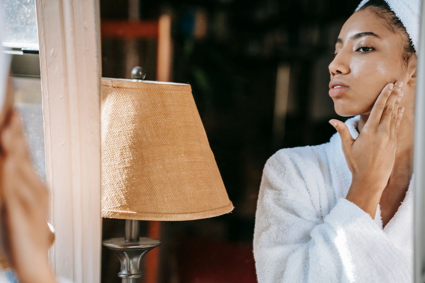A person applying skincare while looking in a mirror