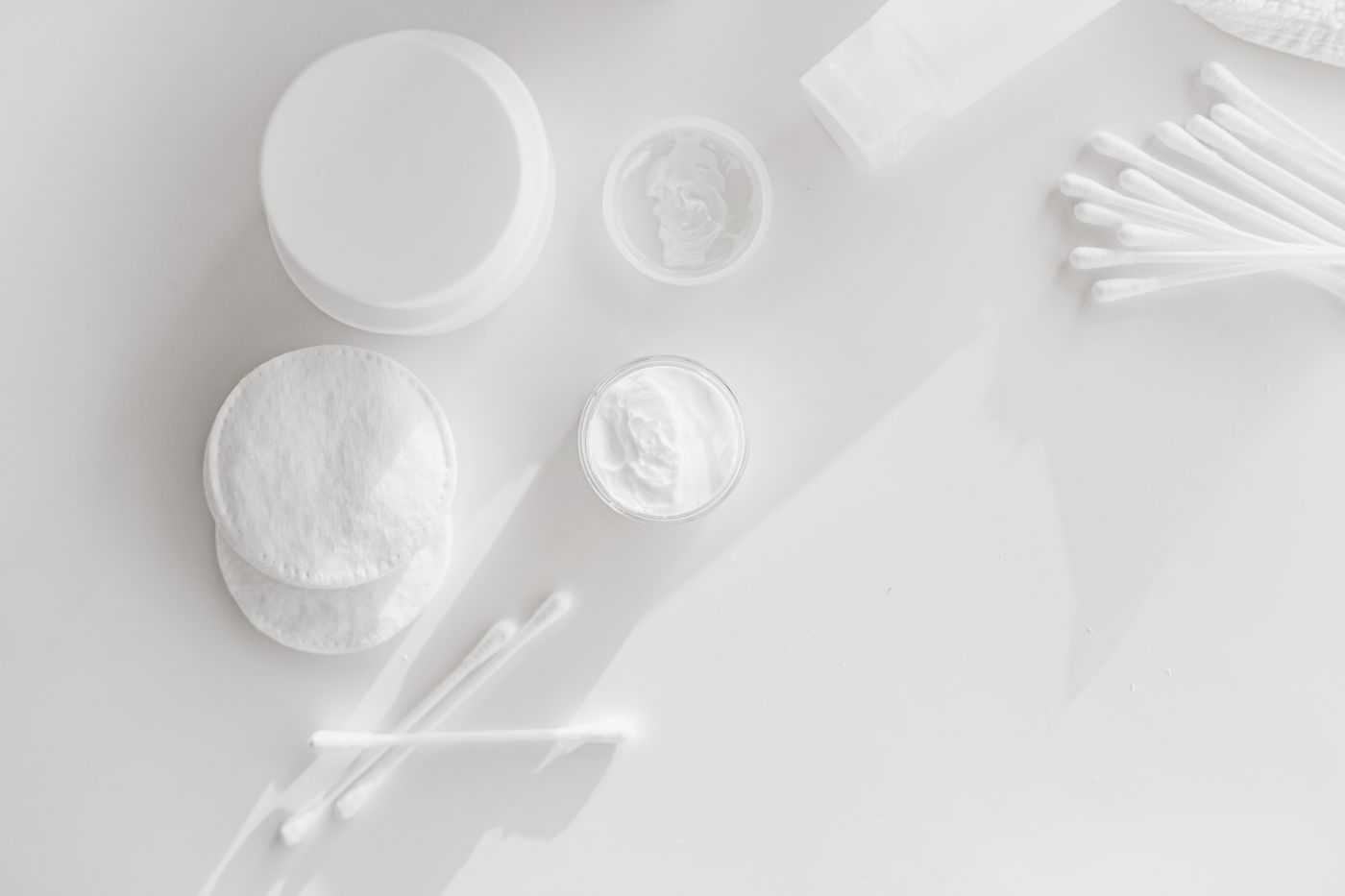 Cotton pads and simple cleansing products arranged on a clean surface