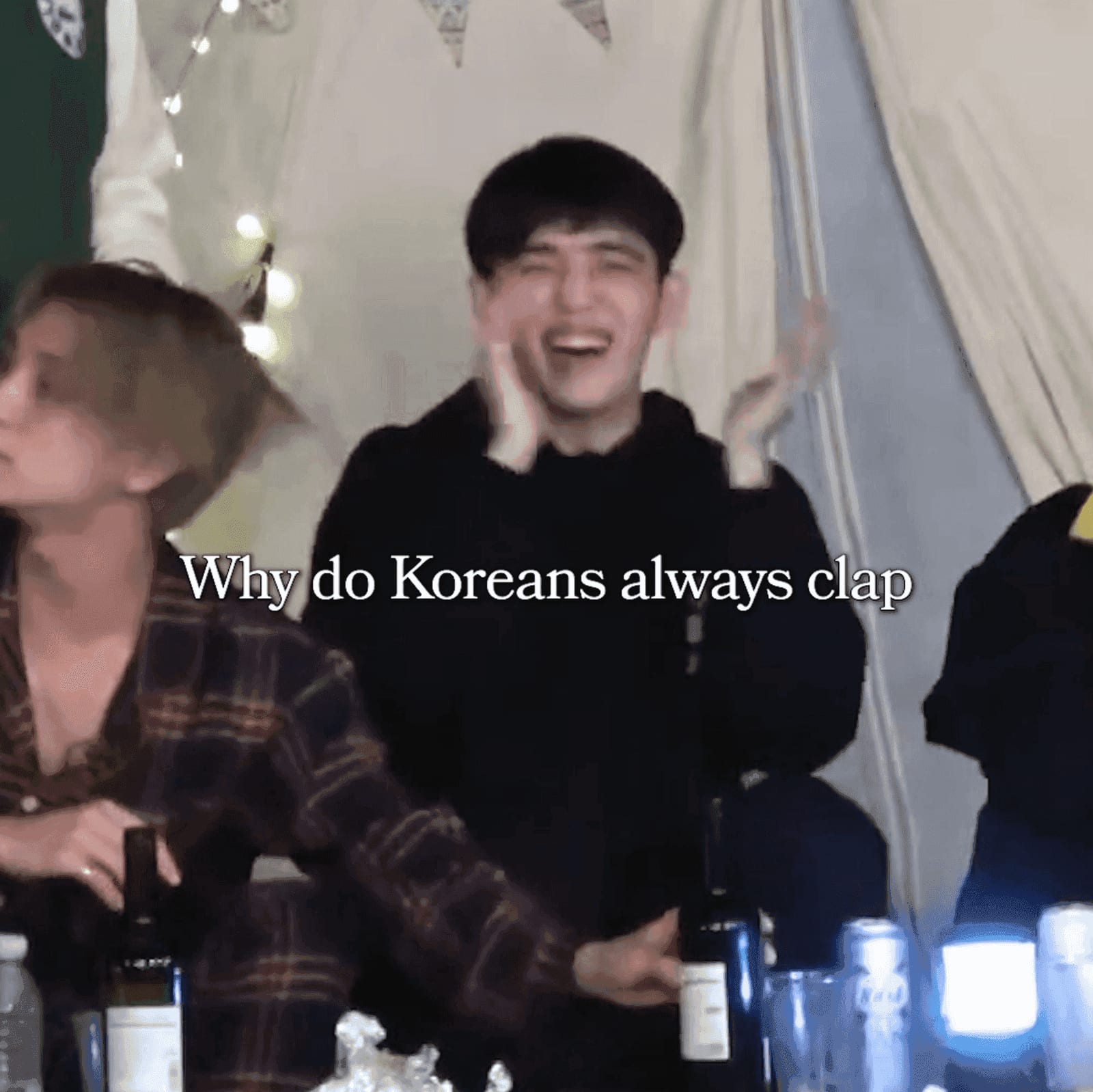 Koreans laughing and clapping in a casual group setting