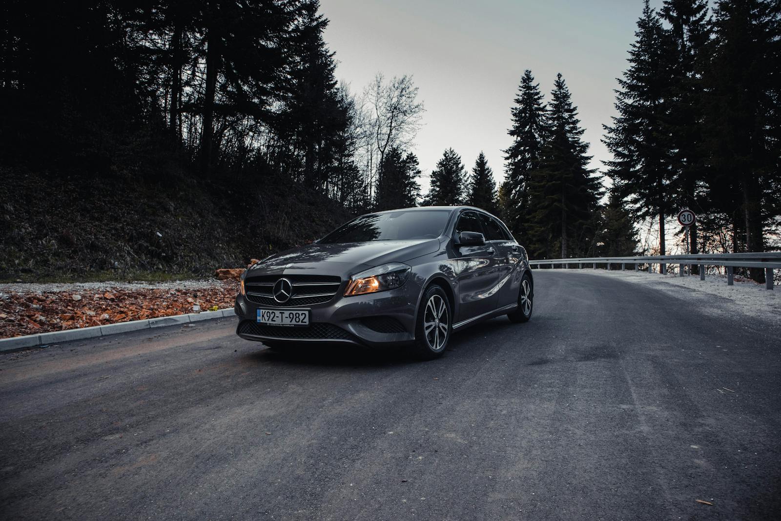 A Mercedes-Benz sedan driving on a wet road, showing how an executive car becomes part of everyday traffic