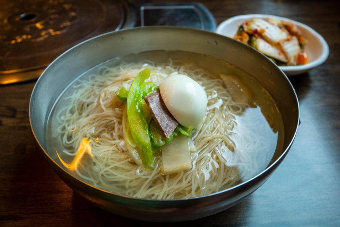 A bowl of mul-naengmyeon, cold buckwheat noodles in chilled broth.
