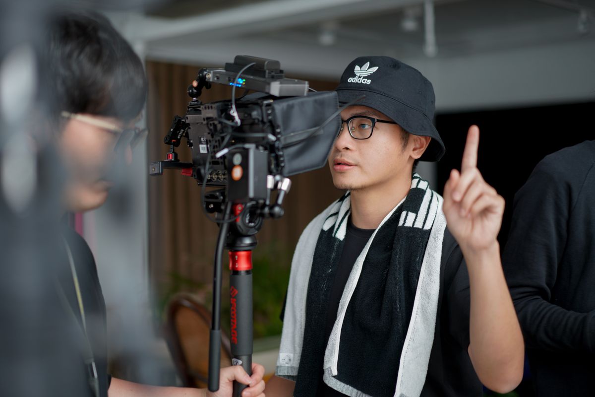 A director managing film-production equipment in a studio setting.