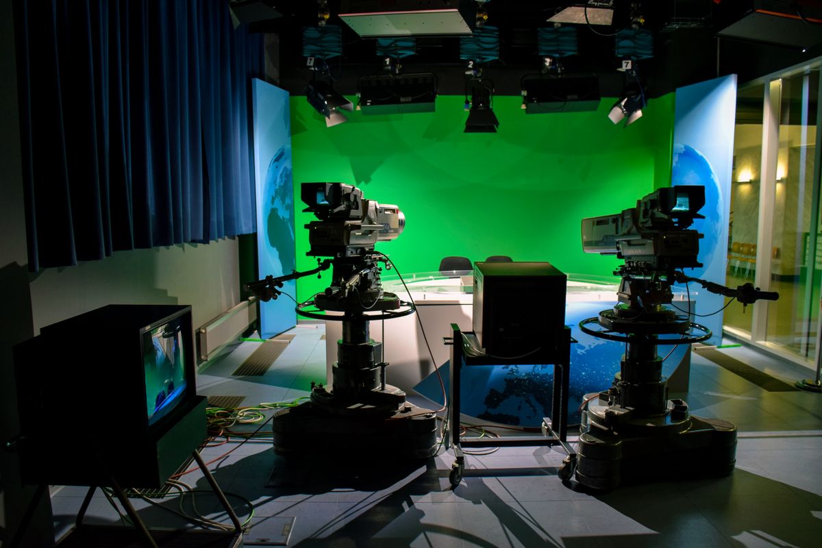 A TV studio camera and green-screen production setup.