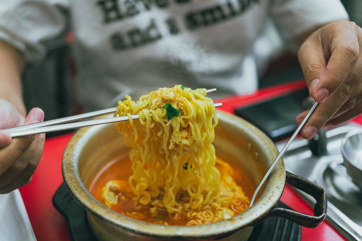 Korean ramen being served hot with chopsticks in Seoul.
