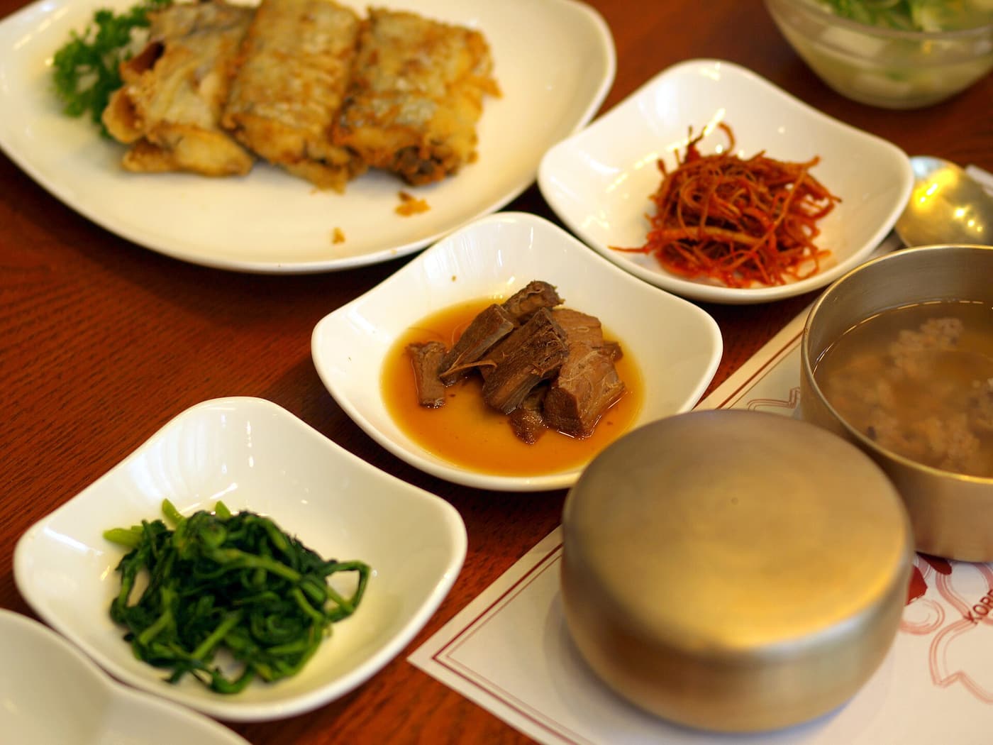 A Korean table set with rice, soup and several small side dishes.