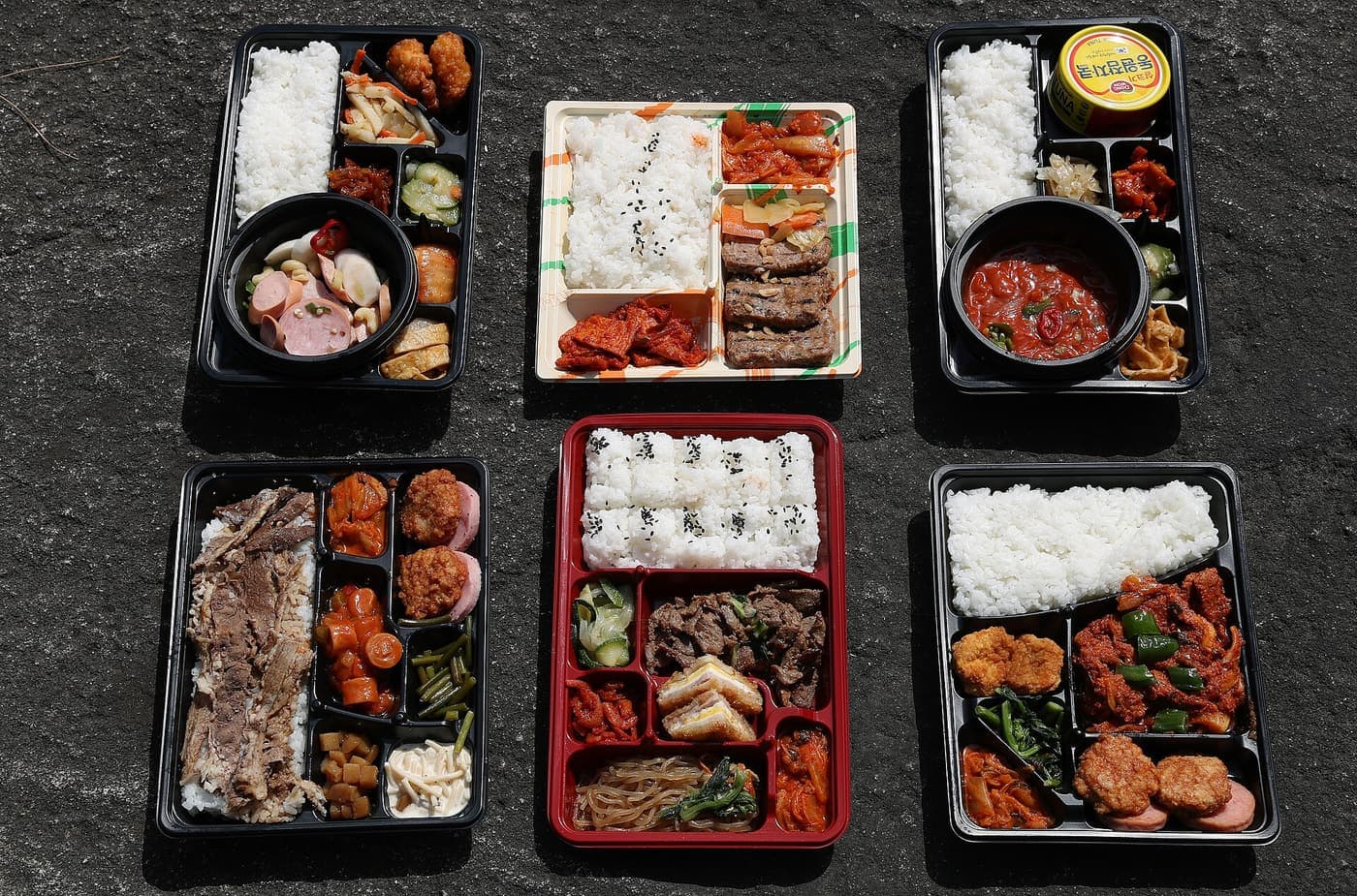 A Korean convenience store lunch box with rice and side compartments.
