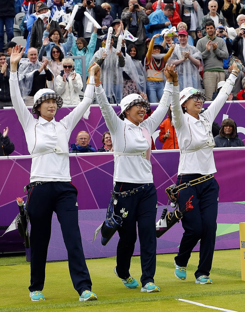 South Korea's women's Olympic archers celebrating together on the field in London.