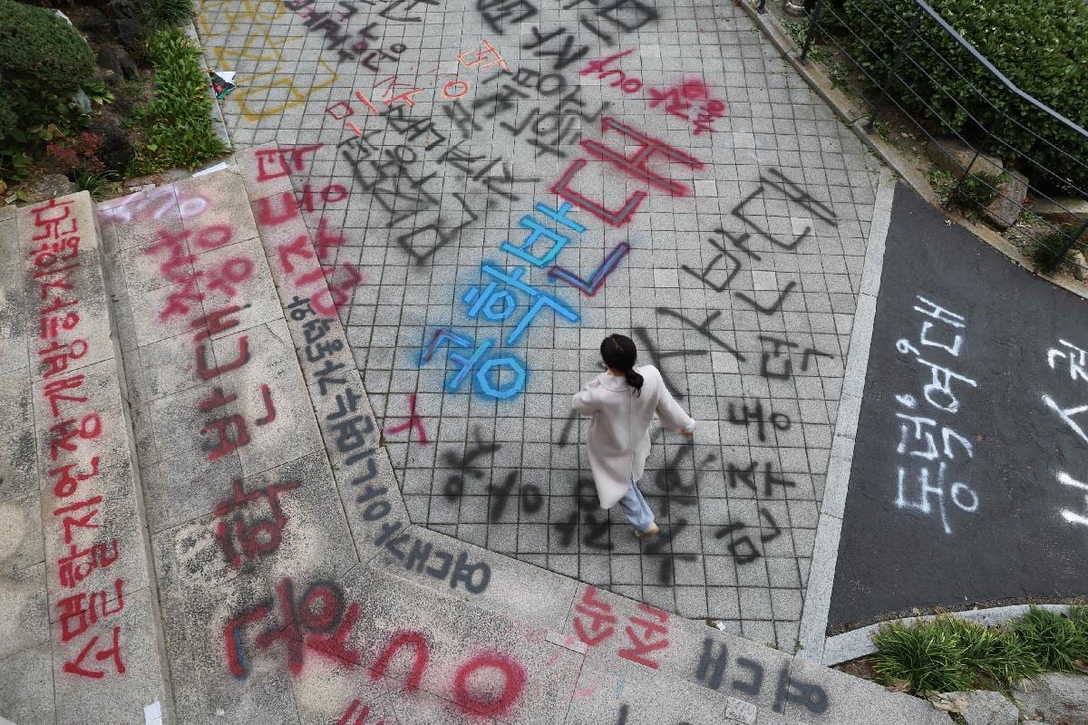 Protest writing across a Dongduk Women's University campus path in November 2024.