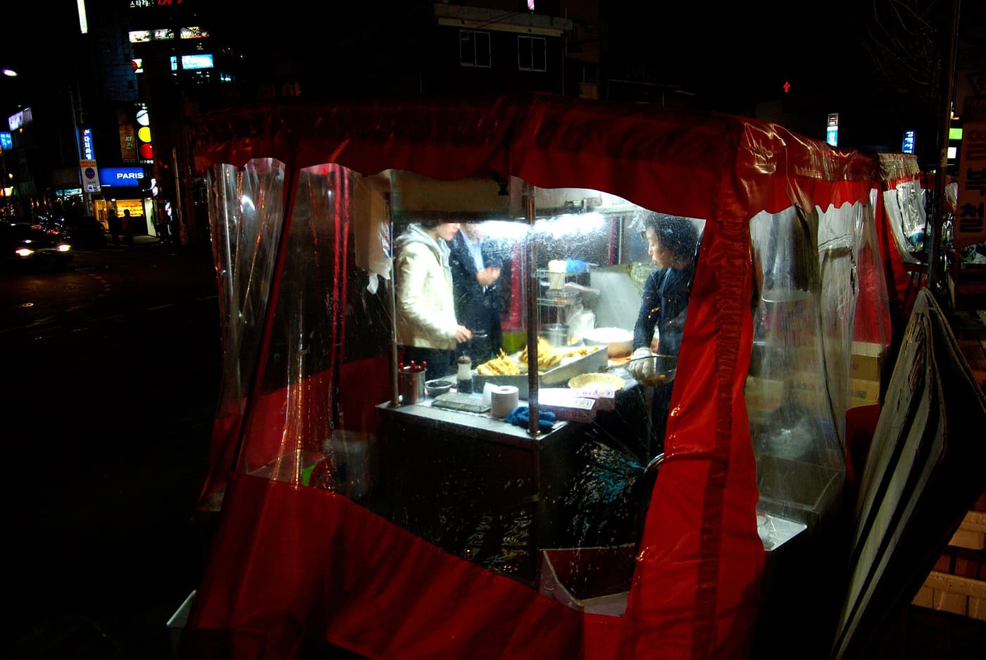 Another Seoul street food stall with trays of prepared food on the counter.