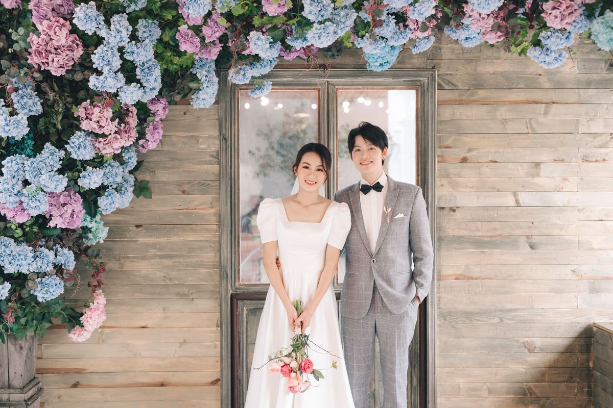 A bride and groom posing in modern wedding clothes