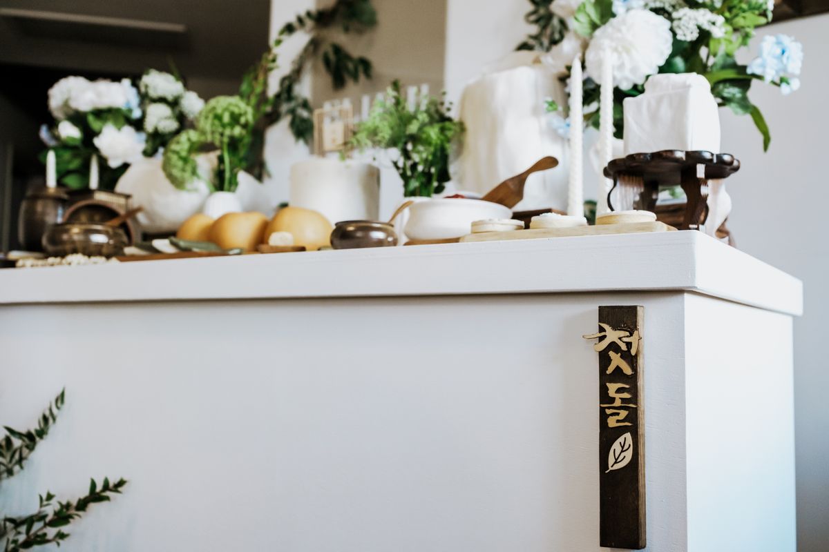 A decorated Korean ceremonial table with flowers and traditional objects