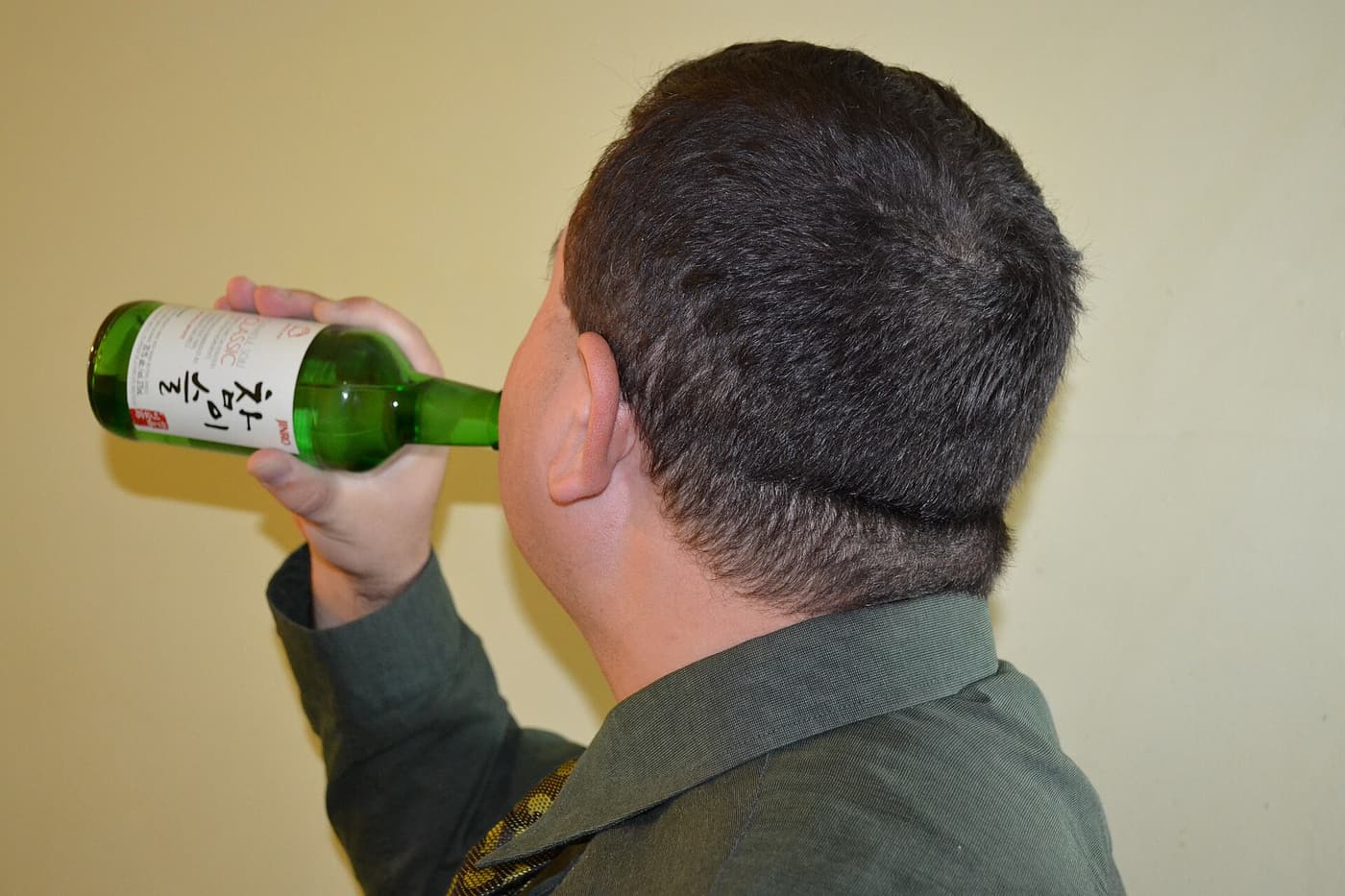 Soju being poured at a Korean table. Almost every drinking game here is built around this bottle, this glass, and whose turn it is to pour.