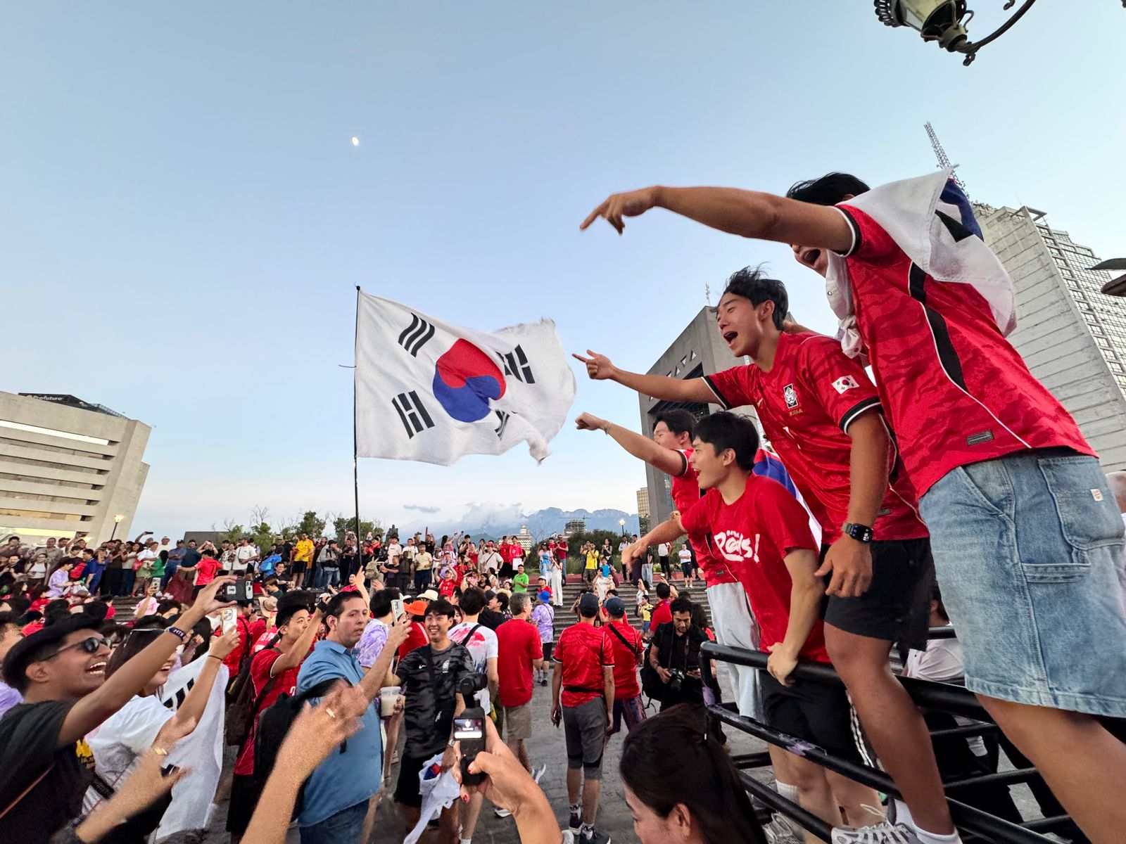 South Korea supporters holding a large Taegukgi at a football match.