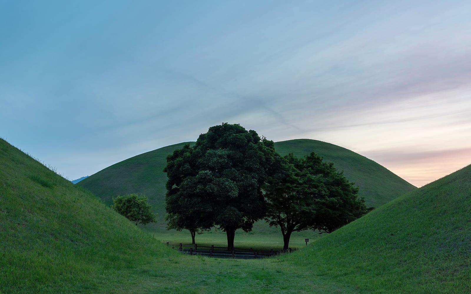 Royal tomb mounds at Daereungwon in Gyeongju at sunset.
