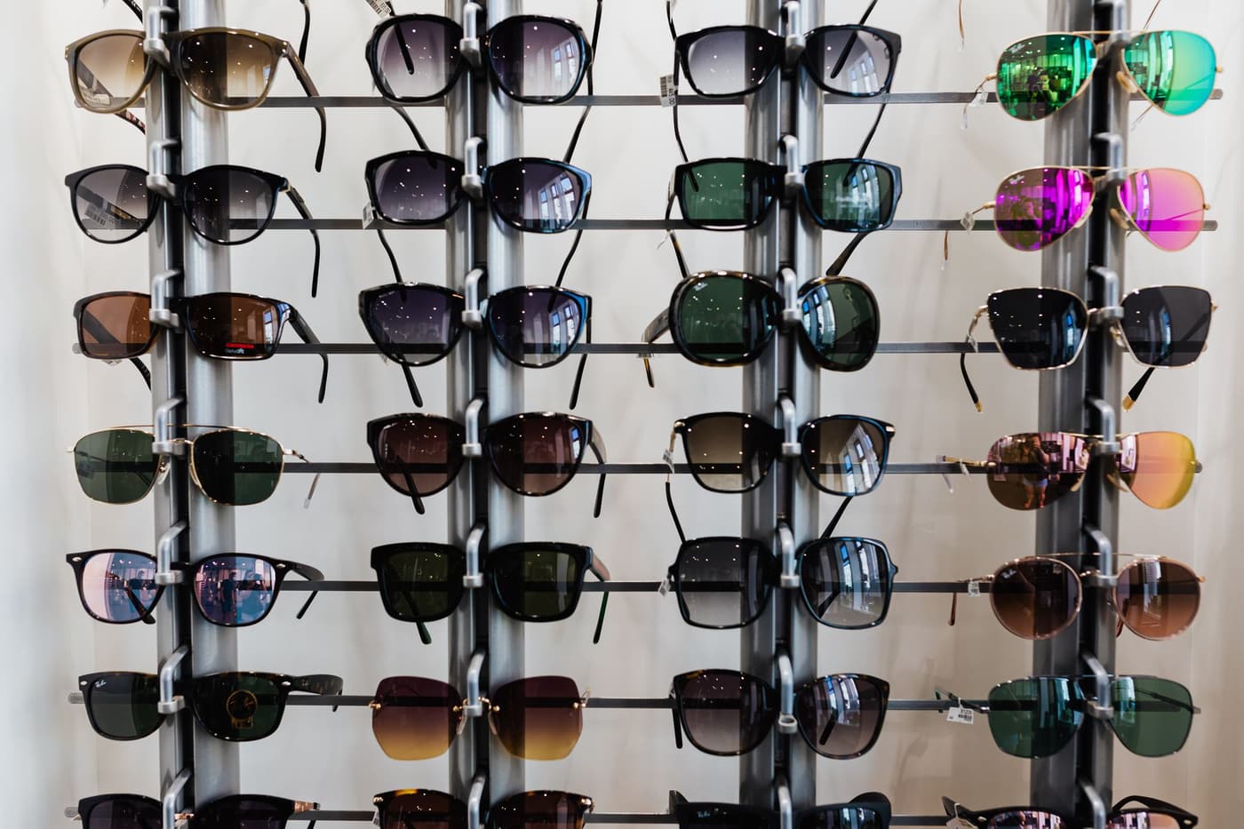 A wall of eyewear on retail display racks, arranged by frame shape.