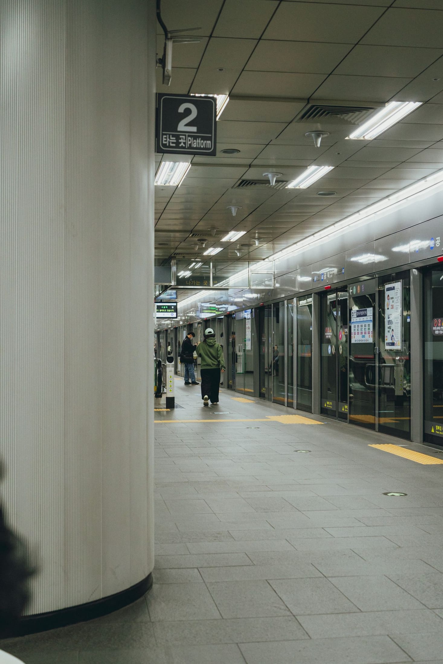 Passengers wait behind platform screen doors at a Seoul subway station.