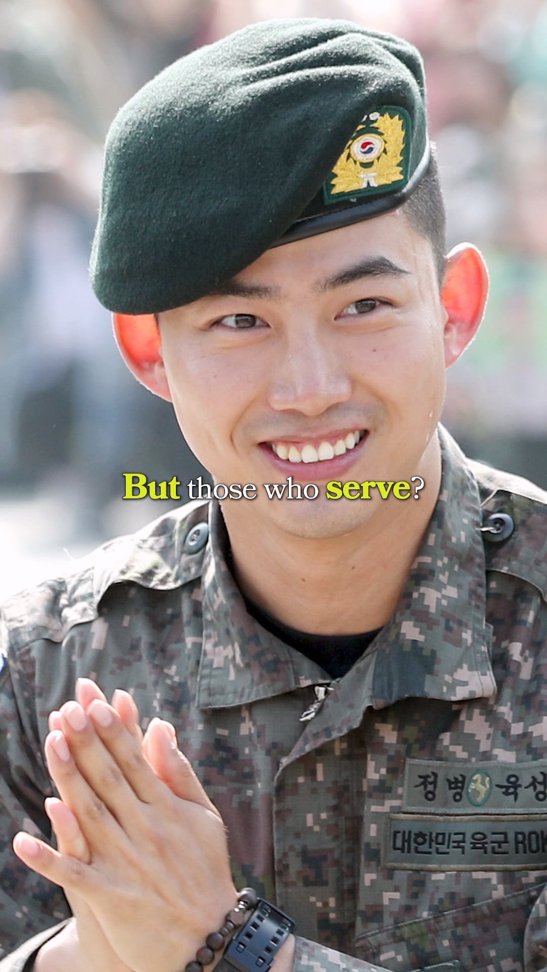 Fans waving purple balloons near a military base entrance