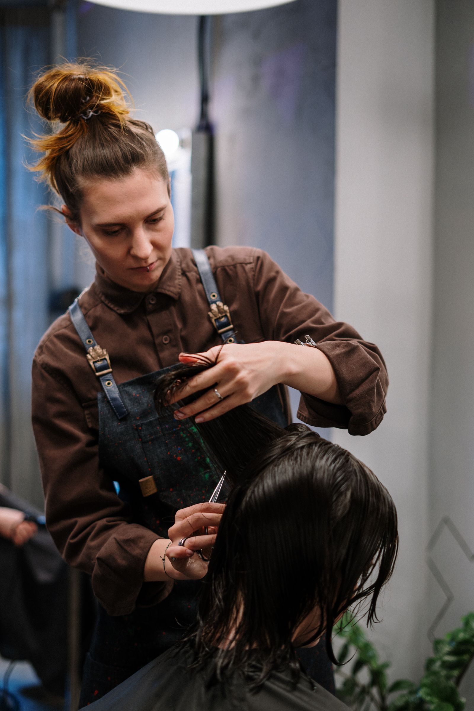 A stylist sectioning wet hair for a precision cut.