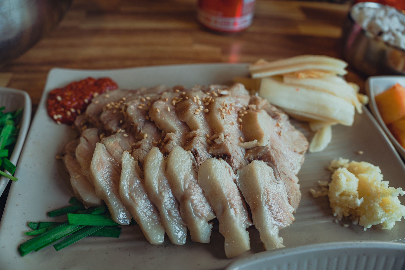 Bossam pork served with kimchi and wrap ingredients