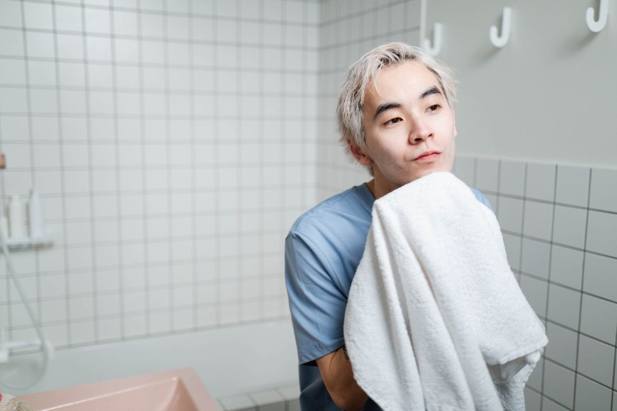 A man drying his face gently after cleansing