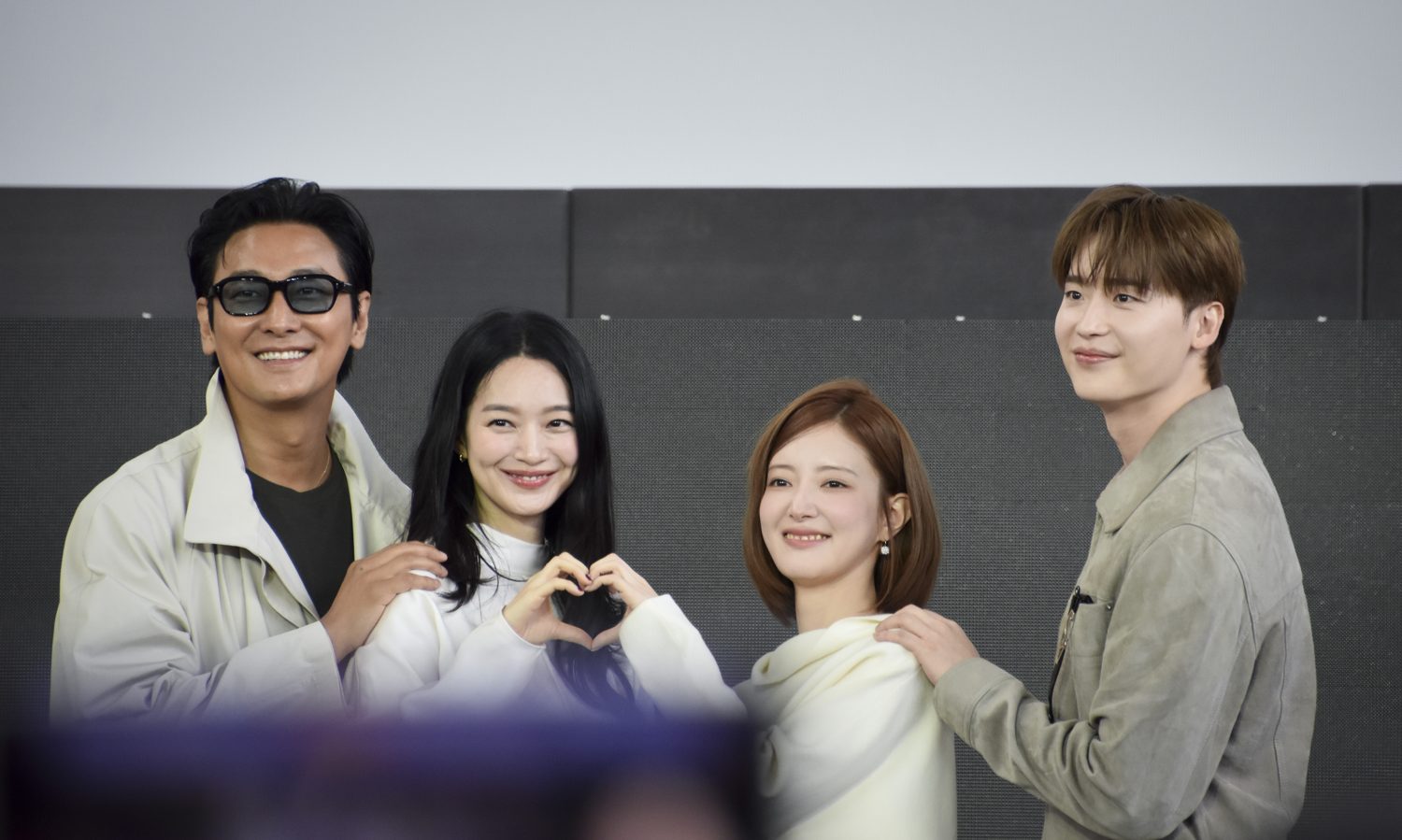 Ju Ji-hoon, Shin Min-a, Lee Se-young and Lee Jong-suk standing together on a stage, Shin Min-a making a heart with her hands, at an open talk event.
