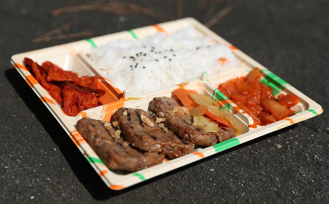 A Korean convenience store meal tray with rice, side dishes and a drink.