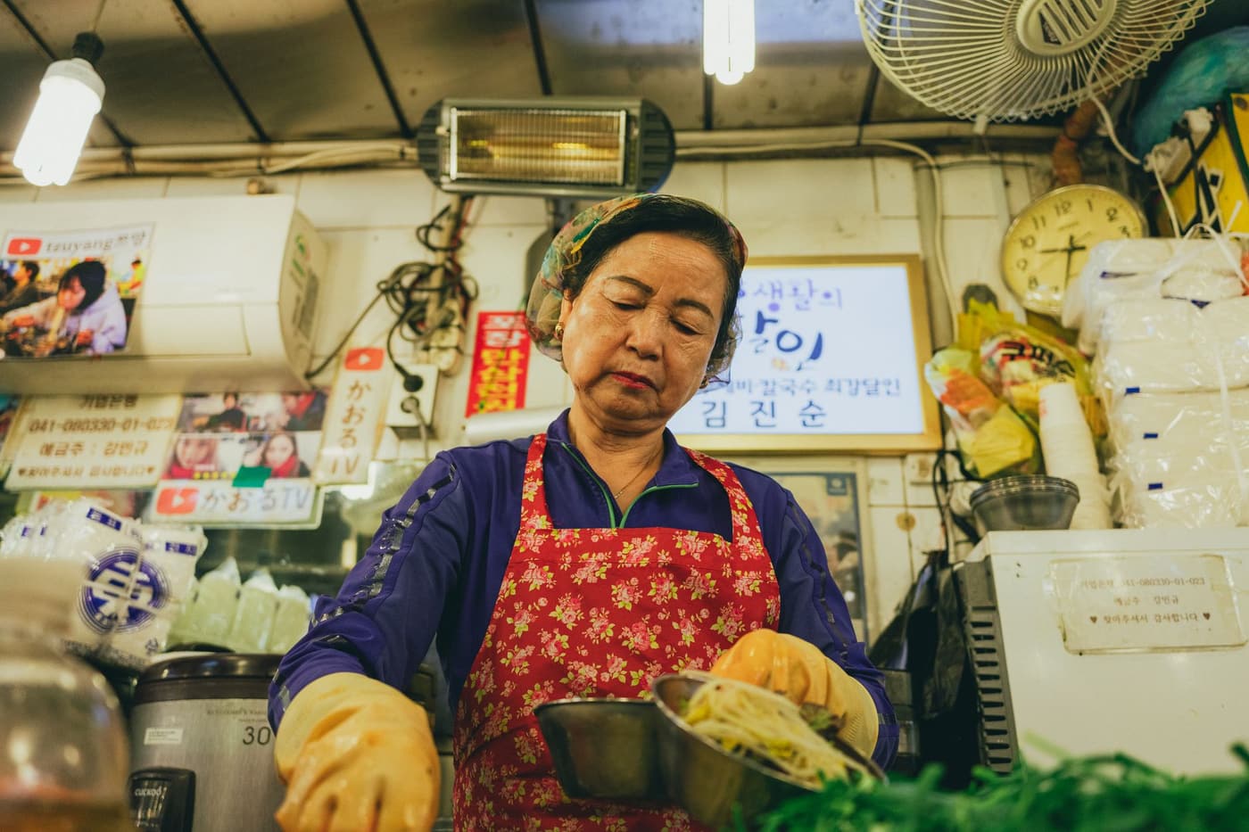 A dedicated Korean vendor preparing food in a bustling Seoul market, showcasing Korean culture and street food.