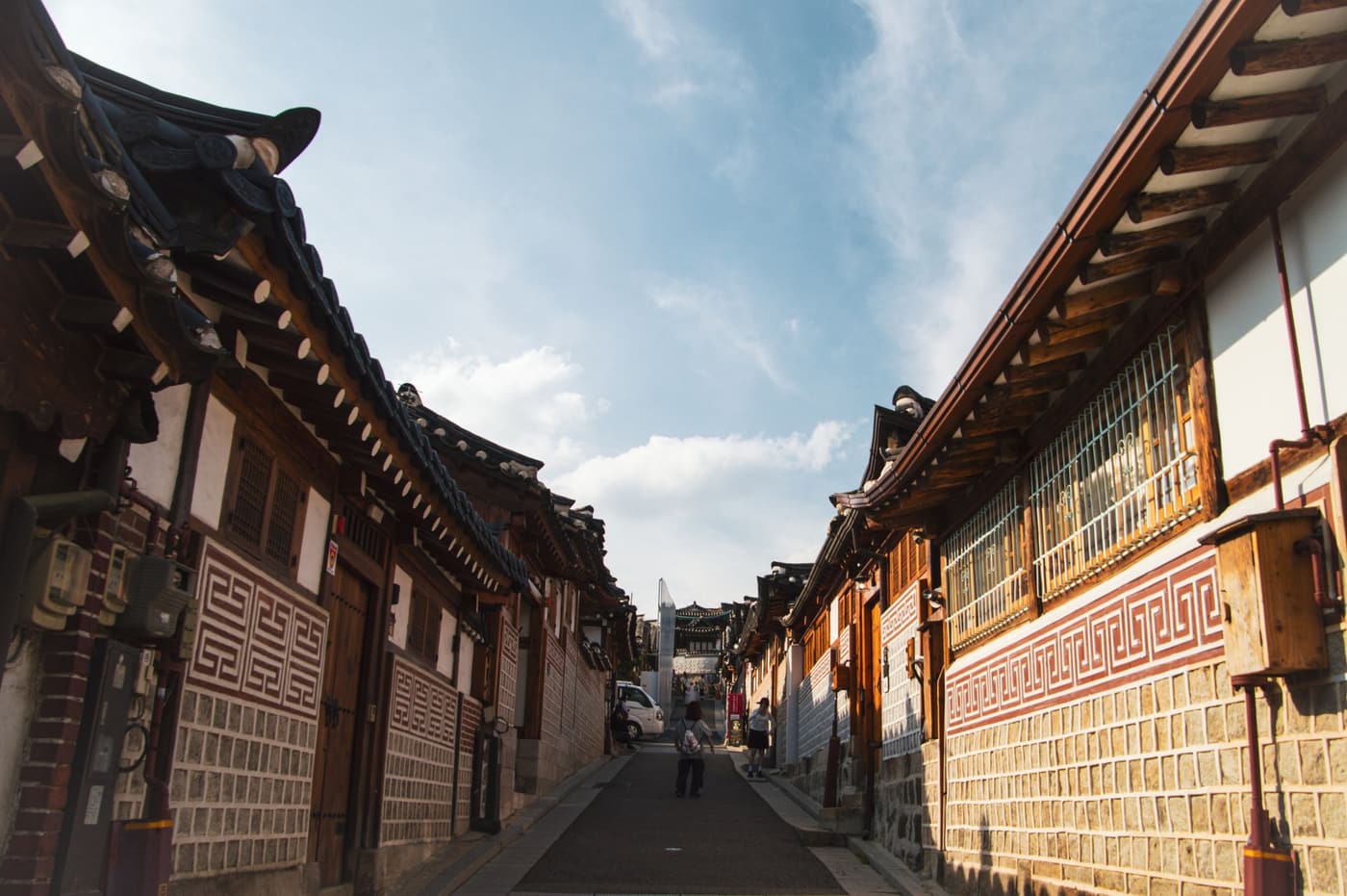 Traditional hanok street in Seoul under clear skies.