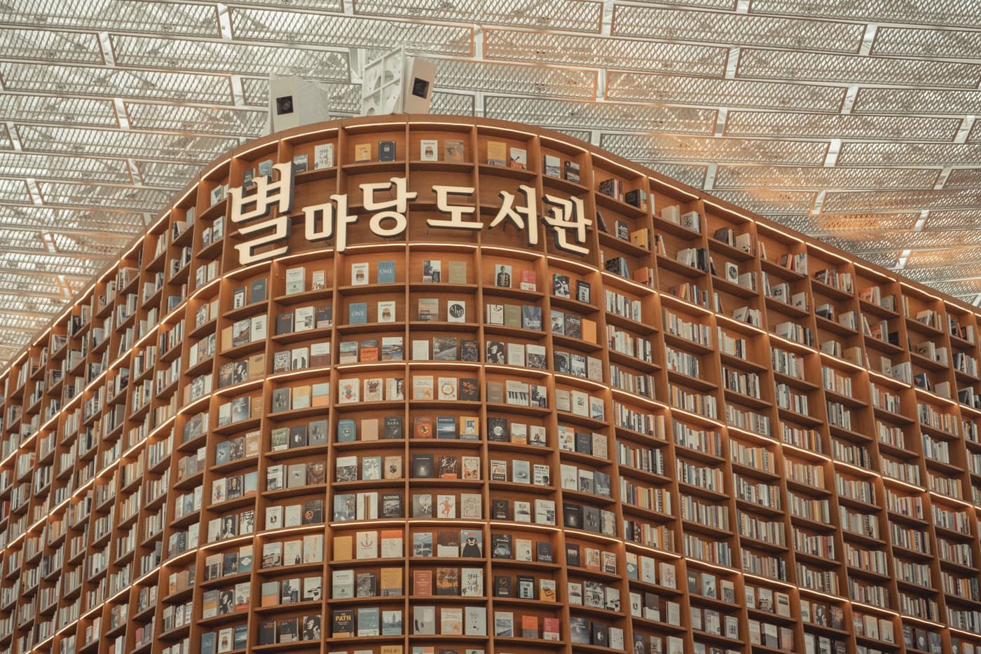 A dramatic view of Starfield Library in Seoul with tall shelves and warm interior lighting.