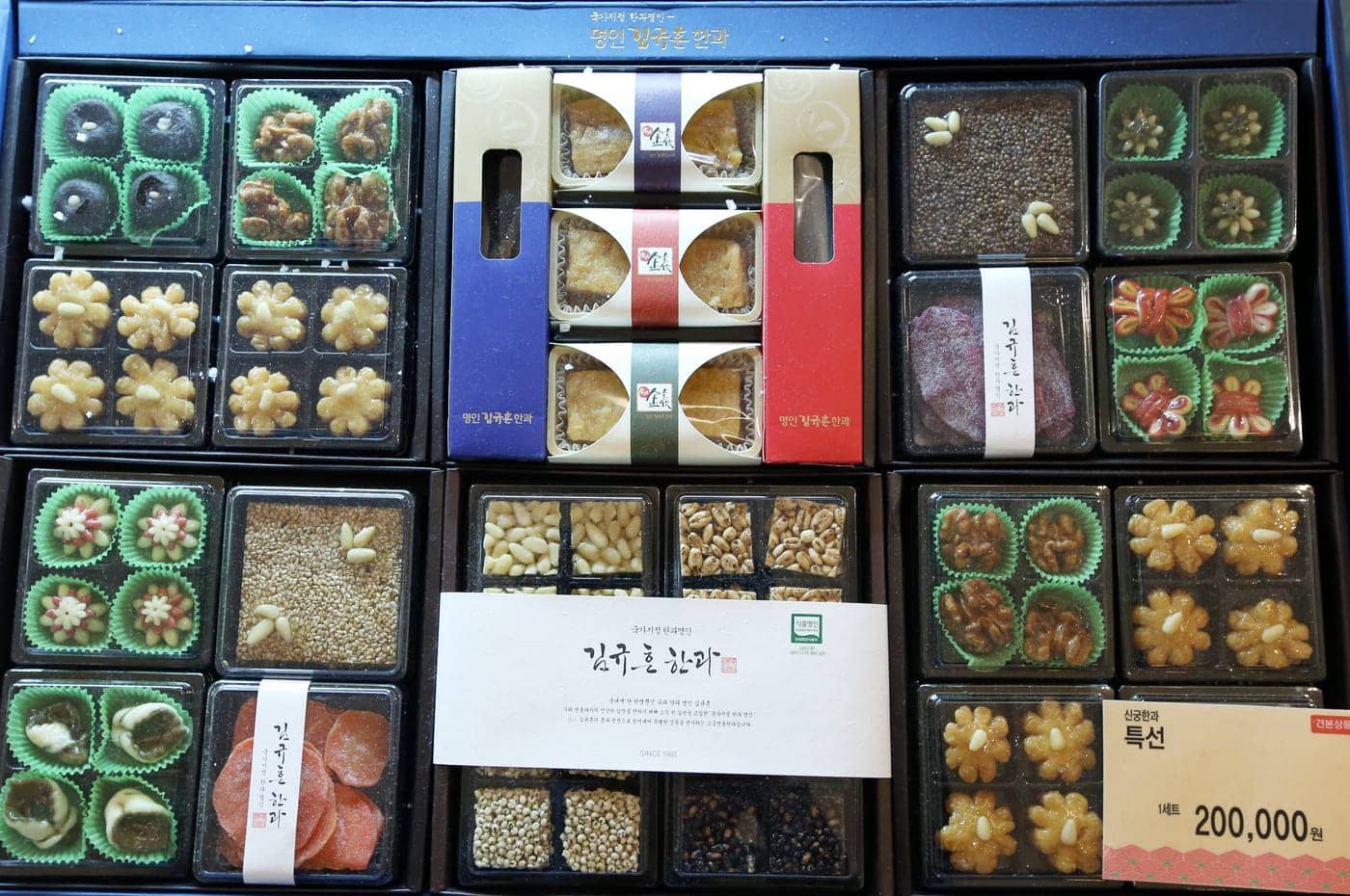 A boxed Korean hangwa gift set, traditional confections arranged in compartments with a maker's card and a price tag reading 200,000 won.