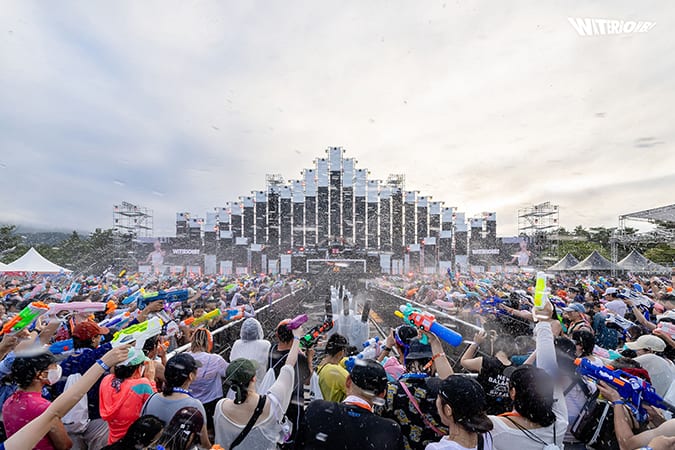 Waterbomb festivalgoers holding water guns in the middle of the crowd