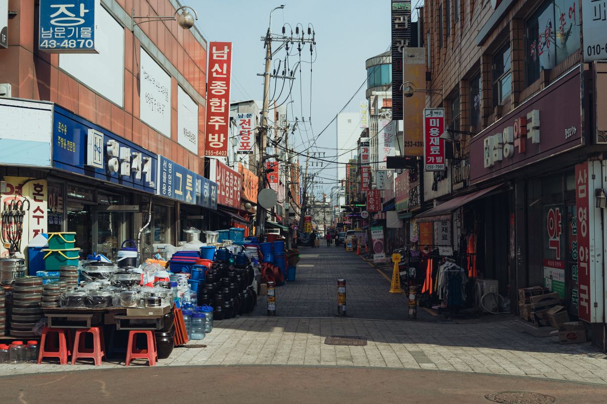 A Seoul shopping street lined with Korean storefronts, showing how beauty retail fits into a normal travel route.