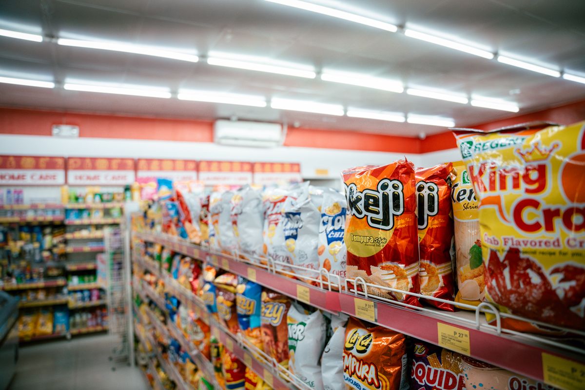 A supermarket snack aisle with colorful packaged snacks.