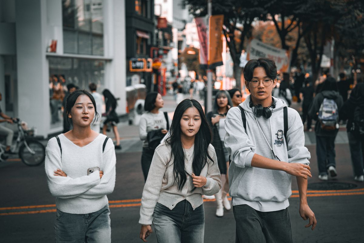 A group of young friends walking through a Seoul street, showing the social side of Korean address terms.