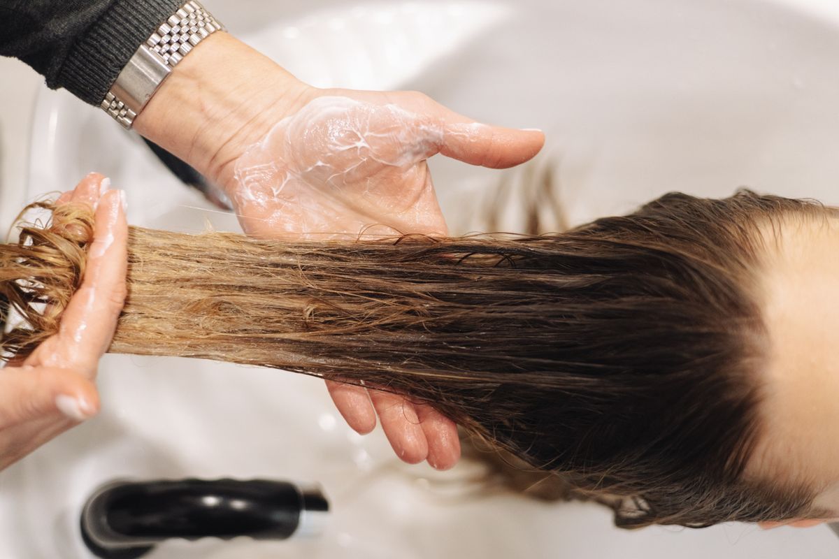 A close-up of a salon scalp-care wash technique.