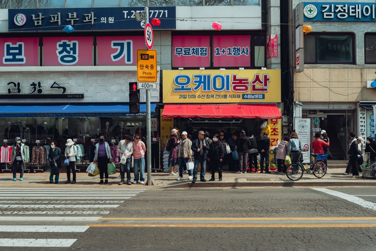 A Seoul street with Korean storefronts and beauty-district browsing energy.
