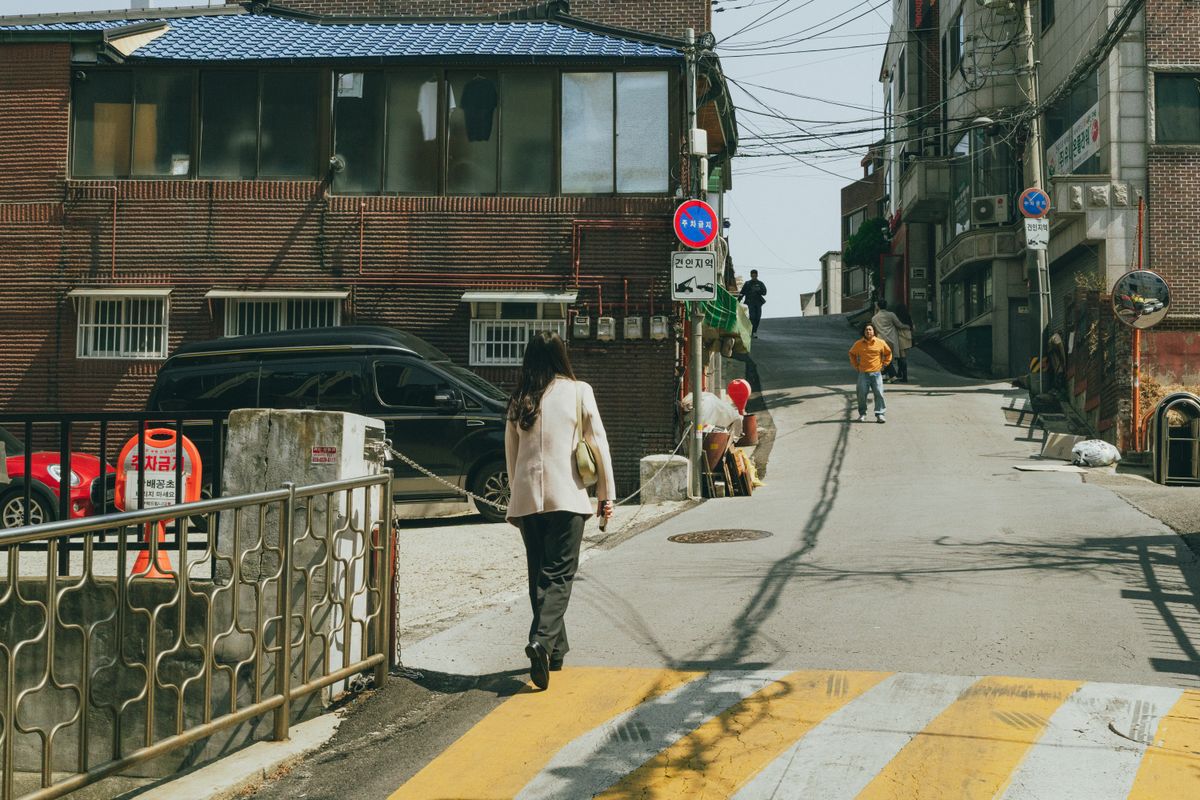A Seoul neighborhood street with Korean storefronts, showing how beauty services fit into everyday city movement.