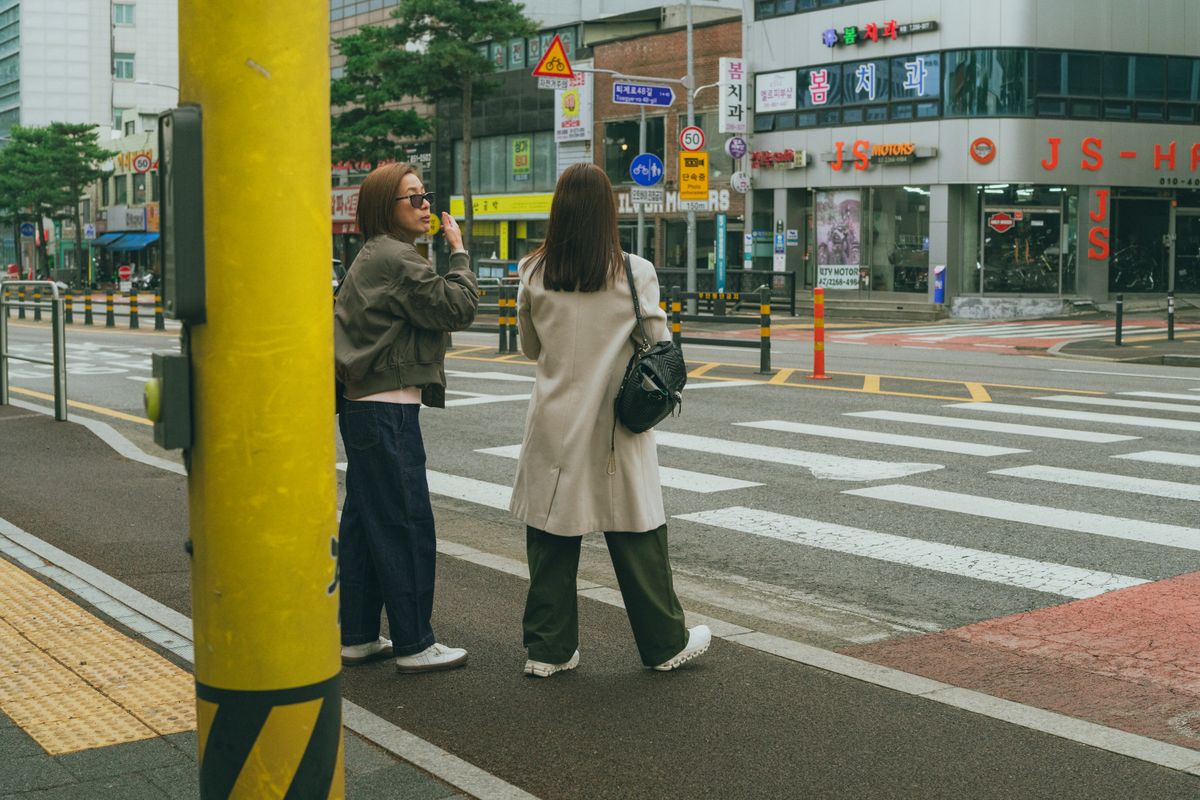 Women walking through a Seoul street, representing how beauty appointments fit into a normal neighborhood travel day.